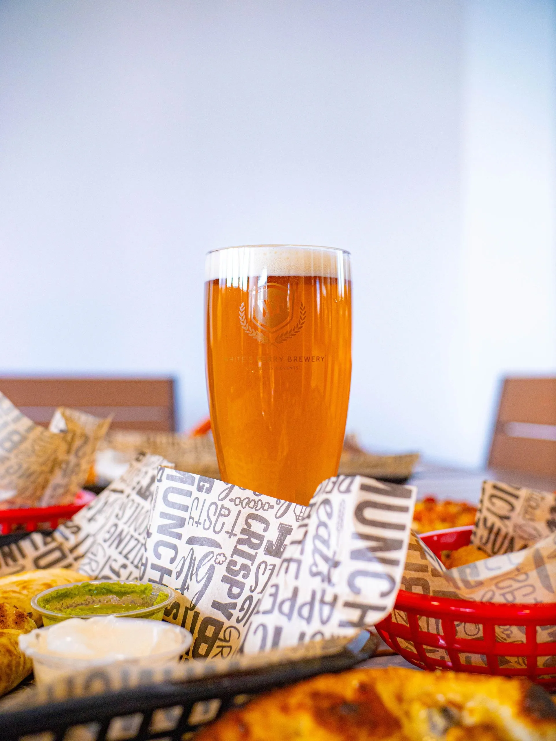 A fresh pour of Whites Ferry beer surrounded by baskets of food